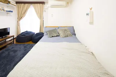 a bedroom with a large bed with a large window at \u30b7\u30a7\u30e2\u30ef\u30ed\u30ef\u30a4\u30e4\u30eb in Tokyo