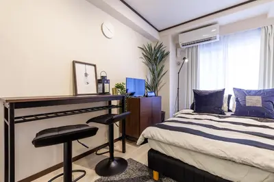 a bedroom with a bed and a desk and a chair at \u30b7\u30a7\u30e2\u30ef\u30ed\u30ef\u30a4\u30e4\u30eb in Tokyo