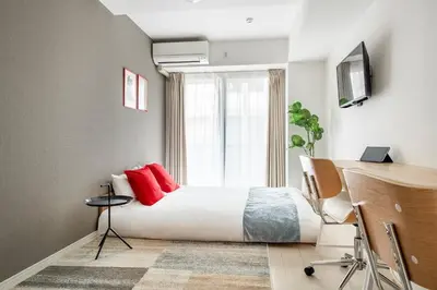 a bedroom with a bed with red pillows and a window at Grande\u68ee\u4e0b in Tokyo