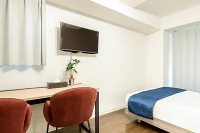 a bedroom with a bed and a desk with a tv at Grande\u68ee\u4e0b in Tokyo
