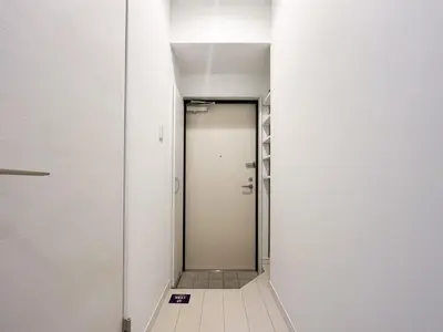 a corridor with a door in a room with white walls at Grande\u68ee\u4e0b in Tokyo