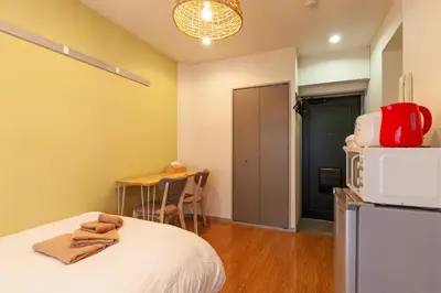 a room with a bed with a microwave and a table at Rej\u30eb\u30d5\u30ec\u6075\u6bd4\u5bff in Tokyo