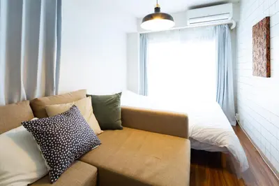 a living room with a couch and a window at \u690d\u7530\u30cf\u30a4\u30c4 in Tokyo