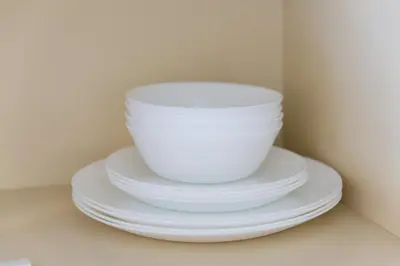 a stack of white bowls and plates on a shelf at \u690d\u7530\u30cf\u30a4\u30c4 in Tokyo