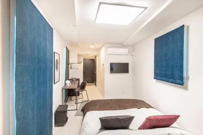 a bedroom with a bed and a desk in a room at \u30ce\u30be\u30df\u30aa\u30d7\u30ec\u30df\u30a2\u660e\u5927\u524d in Tokyo