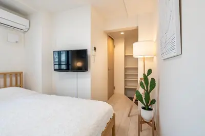 a bedroom with a bed and a tv on a wall at \u30ce\u30be\u30df\u30aa\u30d7\u30ec\u30df\u30a2\u660e\u5927\u524d in Tokyo