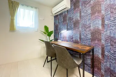 a table and chairs in a room with a wall at \u30ce\u30be\u30df\u30aa\u30d7\u30ec\u30df\u30a2\u660e\u5927\u524d in Tokyo