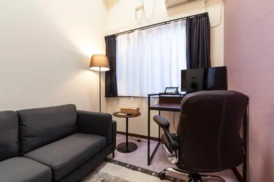 a living room with a couch and a desk with a computer at \u30f4\u30a3\u30f3\u30c6\u30fc\u30b8\u30c7\u30b6\u30a4\u30f3\u795e\u697d\u5742 in Tokyo