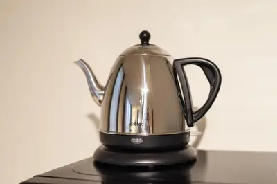 a black and silver tea kettle sitting on a table at \u30f4\u30a3\u30f3\u30c6\u30fc\u30b8\u30c7\u30b6\u30a4\u30f3\u795e\u697d\u5742 in Tokyo