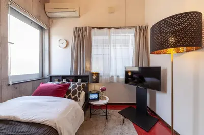 a bedroom with a bed and a flat screen tv at \u30f4\u30a3\u30f3\u30c6\u30fc\u30b8\u30c7\u30b6\u30a4\u30f3\u795e\u697d\u5742 in Tokyo