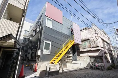 a house with a yellow stairwell on the side of it at \u30f4\u30a3\u30f3\u30c6\u30fc\u30b8\u30c7\u30b6\u30a4\u30f3\u795e\u697d\u5742 in Tokyo