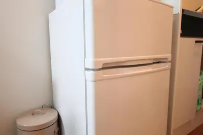a white refrigerator in a kitchen with a trash can at LUANA NOGATA in Tokyo