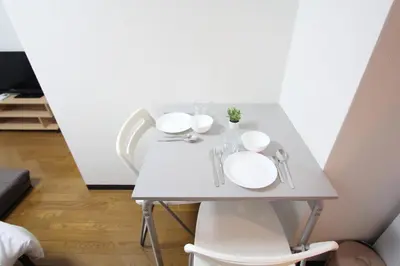 a white table with white plates and glasses on it at LUANA NOGATA in Tokyo