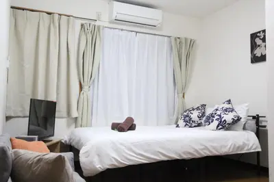 two beds in a room with a window at LUANA NOGATA in Tokyo