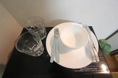 a table with a plate and fork and a glass at LUANA NOGATA in Tokyo