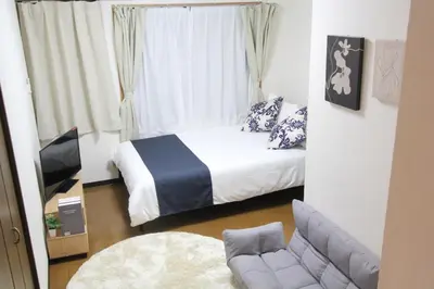 a small bedroom with a bed and a couch at LUANA NOGATA in Tokyo