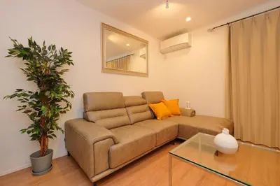 a living room with a brown couch and a mirror at Seirai Vacation Rental Hatsudai - Vacation STAY 15951v in Tokyo