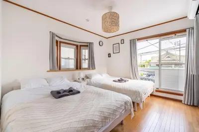 two beds in a room with a window at BISK PARK TOKYO - 4LDK&2Bath Spacious House - Easy Access to Asakusa, Skytree & Airport in Tokyo