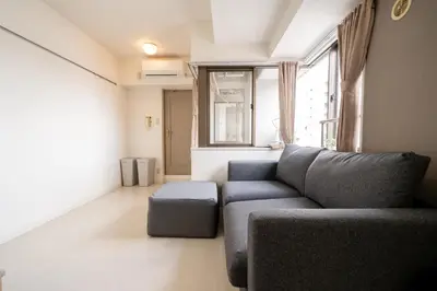 a living room with a blue couch and a window at Nishinippori Guest House -Sendagi house- , elevator , private kitchen , private bathroom in Tokyo