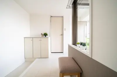 a white hallway with a chair and a window at Nishinippori Guest House -Sendagi house- , elevator , private kitchen , private bathroom in Tokyo