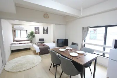 a living room with a table and chairs and a living room at LUANA ARAI in Tokyo