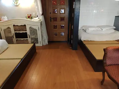 a room with two beds and a table and a door at \u85e4\u7d2bFujiMurasaki Japanese classic House in Tokyo