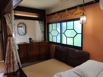 a bedroom with a window with a chair and a mirror at \u85e4\u7d2bFujiMurasaki Japanese classic House in Tokyo