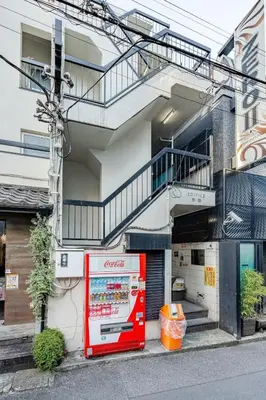 a soda machine is parked outside of a building at \u6e0b\u8c37\u99c5\u5f92\u6b696\u5206!\u9ad8\u901f\u30a4\u30f3\u30bf\u30fc\u30cd\u30c3\u30c8\u5149\u56de\u7dda in Tokyo
