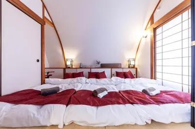 a bedroom with a large bed with red pillows at \u30e1\u30c7\u30a3\u30a2\u30b3\u30f3\u30d7\u30ec\u30c3\u30af\u30b9\u30d3\u30eb in Tokyo
