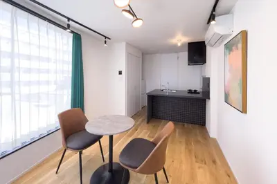 a room with a table and chairs and a kitchen at \u30c8\u30ea\u30a2\u30b9540 in Tokyo