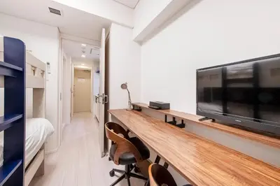 a room with a tv and a desk with chairs at \u30d6\u30ea\u30ea\u30a2\u30f3\u30c8mk-III in Tokyo