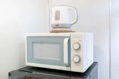 a white microwave sitting on a shelf with a blender on top at \u30d6\u30ea\u30ea\u30a2\u30f3\u30c8mk-III in Tokyo