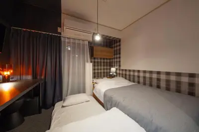 a hotel room with two beds and a window at \u30b5\u30f3\u30d1\u30ec\u30b9\u897f\u65b0\u5bbf in Tokyo