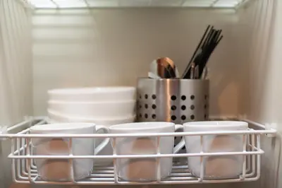 a shelf in a refrigerator filled with dishes and utensils at \u30b5\u30f3\u30d1\u30ec\u30b9\u897f\u65b0\u5bbf in Tokyo