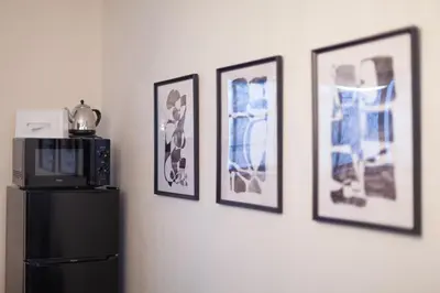 a kitchen with a refrigerator and pictures on the wall at Nsk\u30d3\u30eb in Tokyo