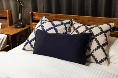 a bed with blue and white pillows on it at Nsk\u30d3\u30eb in Tokyo
