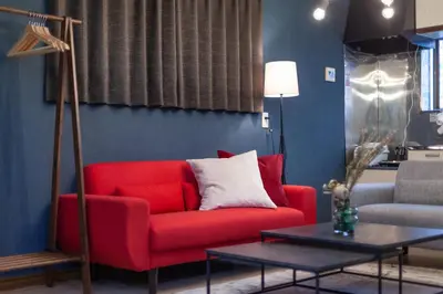 a living room with a red couch and a table at Nsk\u30d3\u30eb in Tokyo