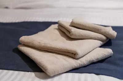a pile of towels sitting on top of a bed at Nsk\u30d3\u30eb in Tokyo