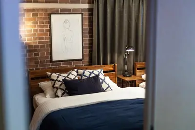 a bedroom with a bed and a brick wall at Nsk\u30d3\u30eb in Tokyo
