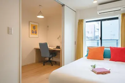 a bedroom with a bed with a desk and a window at \u30d6\u30ed\u30c3\u30b5\u30e0\u30c6\u30e9\u30b9\u4e21\u56fd in Tokyo