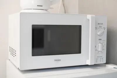 a white microwave oven sitting on top of a counter at \u30d6\u30ed\u30c3\u30b5\u30e0\u30c6\u30e9\u30b9\u4e21\u56fd in Tokyo