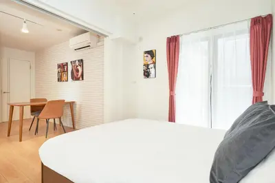 a bedroom with a bed and a table and a window at \u30d6\u30ed\u30c3\u30b5\u30e0\u30c6\u30e9\u30b9\u4e21\u56fd in Tokyo