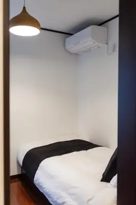 a small bedroom with a white bed and a light at \u90fd\u5fc3\u7e01\u6e0b\u8c37 in Tokyo