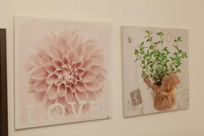 two pictures of flowers are hanging on a wall at \u90fd\u5fc3\u7e01\u6e0b\u8c37 in Tokyo