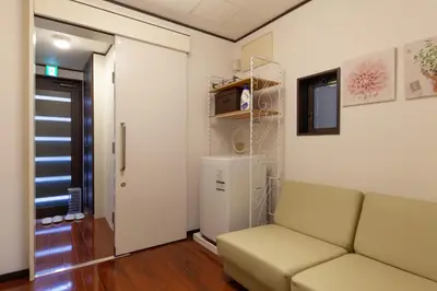 a living room with a couch and a refrigerator at \u90fd\u5fc3\u7e01\u6e0b\u8c37 in Tokyo