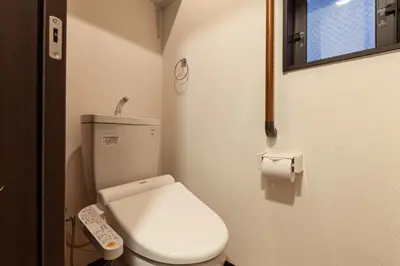 a small bathroom with a toilet and a remote control at \u90fd\u5fc3\u7e01\u6e0b\u8c37 in Tokyo