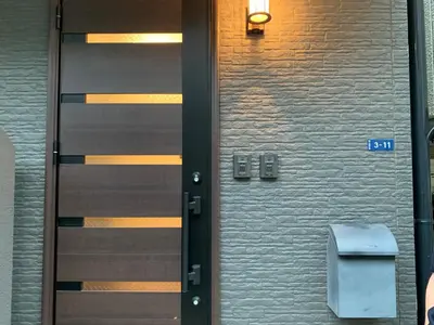 a door with a trashcan next to a brick wall at \u90fd\u5fc3\u7e01\u6e0b\u8c37 in Tokyo