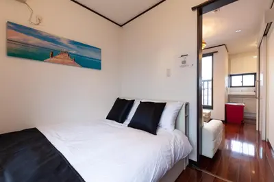 a bedroom with a white bed with black pillows at \u90fd\u5fc3\u7e01\u6e0b\u8c37 in Tokyo