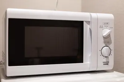 a white microwave oven sitting on top of a counter at \u30e1\u30be\u30f3\u516d\u672c\u6728 in Tokyo