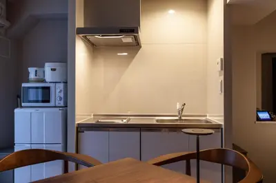 a kitchen with a sink and a table with chairs at \u30e1\u30be\u30f3\u516d\u672c\u6728 in Tokyo